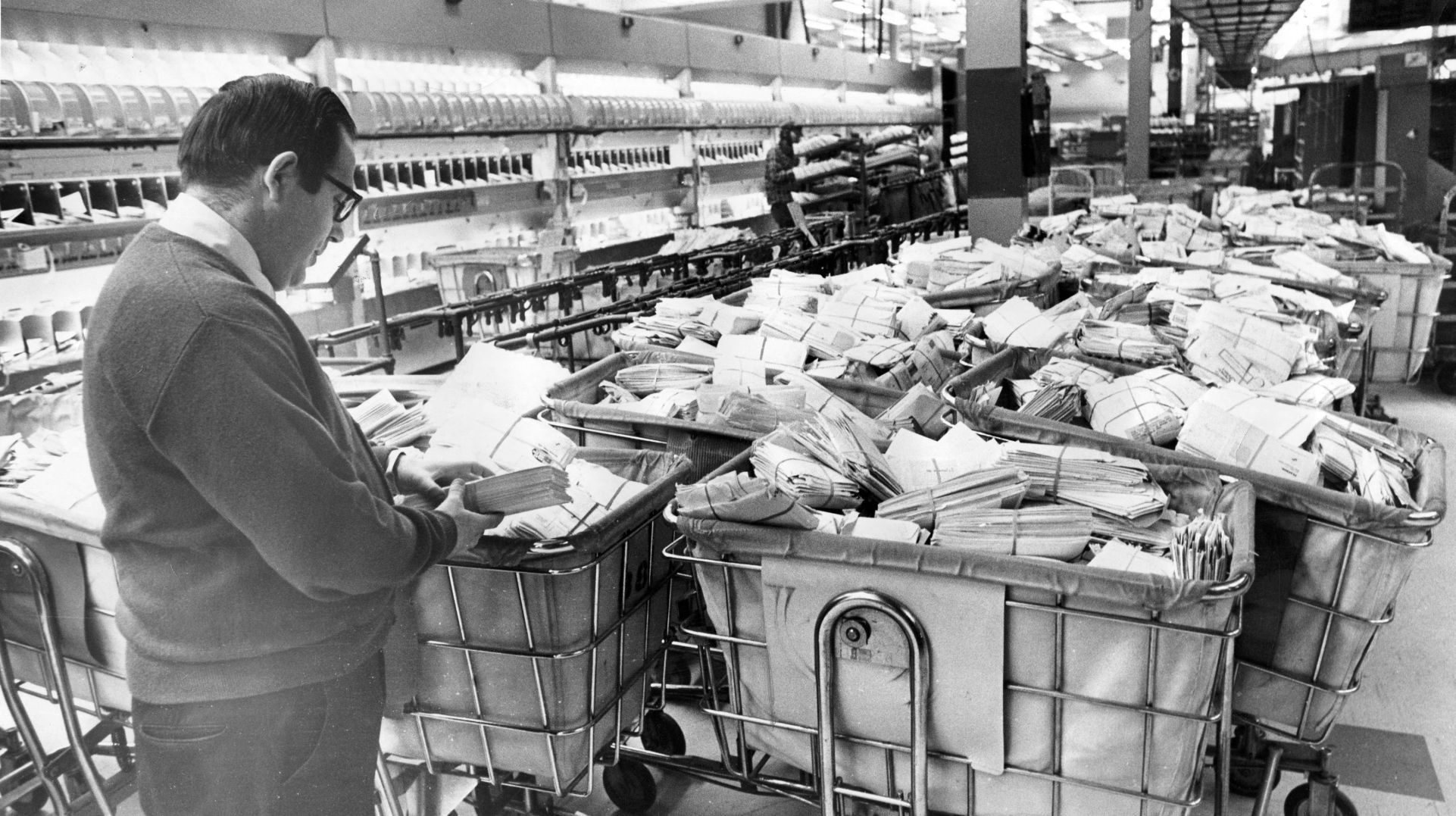 Gary Lowman, manpower coordinator of the Postal Service, sorts through the overflow of about 20,000 pounds of mail on Jan. 12, 1975. Service had been delayed due to the blizzard and postal trucks were still stranded on the streets, many of which had mail in them.